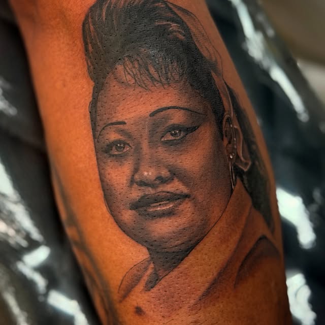 Close-up of a detailed black-and-grey portrait tattoo